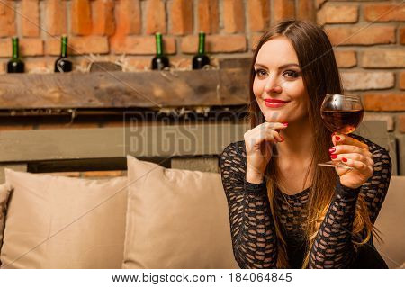 Woman Tasting Wine In Rural Cottage Interior