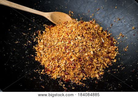 Roasted Thai spicy seasoning chili garlic salt and peppers in traditional black pan.