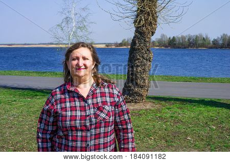 A portrait of a happy smiling woman on a background of river