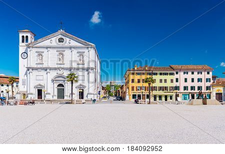 Palmanova - April 2016, Italy: Central square in The Fortress - Town of Palmanova, view on Cathedral and colored houses in traditional architecture style