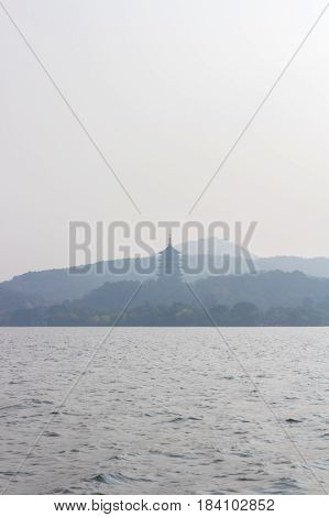 Landscape with the lake and mountains. West Lake Leifeng Pagoda in Hangzhou. Chinese tower and garden for recreation.