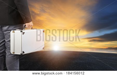 business man and steel breifcase standing on wide road and sun rising sky for business opportunity concept