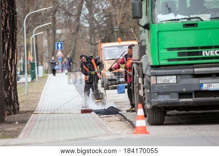 Carnikava, Latvia - April 28, 2017: Workers on a road construction, industry and teamwork.