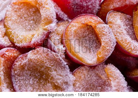 frozen half of a plum on a wooden background. Winter vitamins