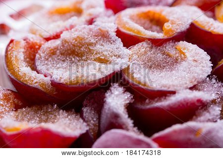 frozen half of a plum on a wooden background. Winter vitamins