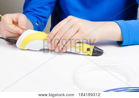 Kids hand holding 3d printing drawing pen.