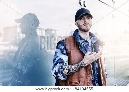 A Rap Singer Is Reflected In A Blue Mirror On The Outskirts