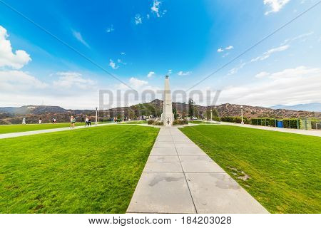 Los Angeles CA USA - Obelisk in Griffith park with Hollywood sign in the background