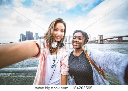Couple of friends looking at tablet close to the river in New york city