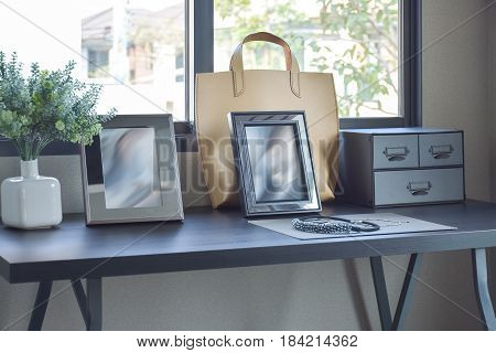 female's accessories with handbag and jewelry on wooden dressing table