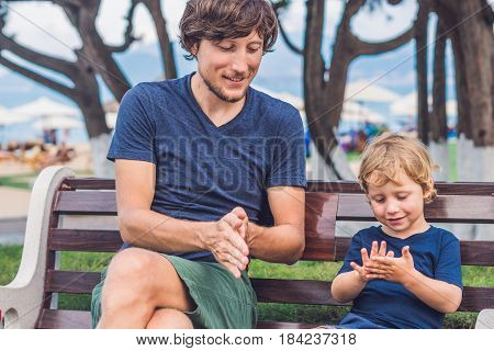 Father And Son Eat Fried Sweet Potatoes In The Park. Junk Food Concept