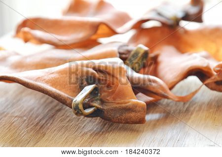 dog snack dried ear cow with loop made from real meat on wooden board