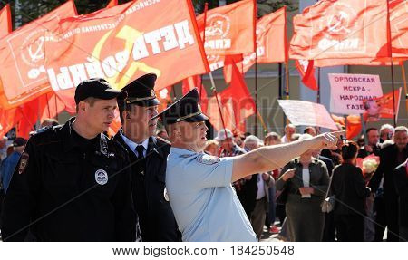 Orel Russia - May 1 2017: May demonstration. Policemen in front of crowd with red Communist flags background