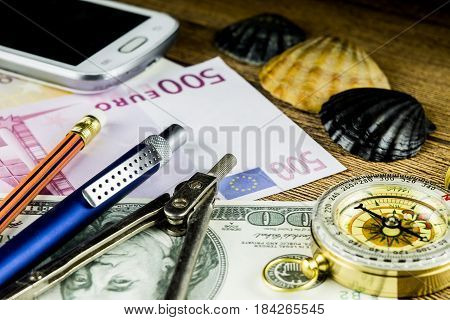 Pensil in travel composition with fotocameramoney and other acsessories on the wooden table