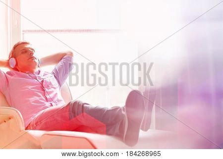 Full-length of relaxed Middle-aged man listening to music at home