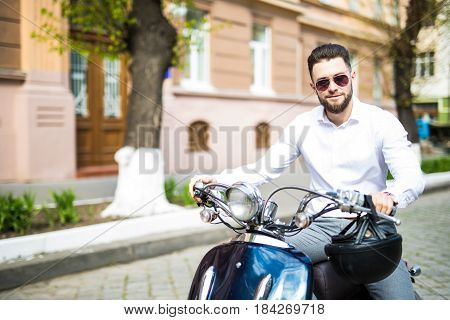 Portrait Of Serious Young Businessman On Motorbike On City Street