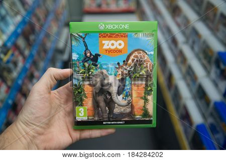 Bratislava, Slovakia, circa april 2017: Man holding Zoo Tycoon videogame on Microsoft XBOX One console in store