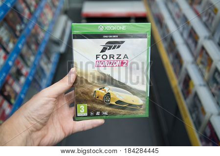 Bratislava, Slovakia, circa april 2017: Man holding Forza Horizon 2 videogame on Microsoft XBOX One console in store
