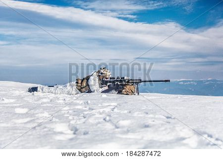 Army soldier with Sniper rifle in action in the Arctic. He lies in the snow desert, suffering from extreme cold, but waiting as long as enemies appear to kill them