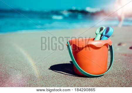 Vacation image of children's beach toys on the sand in beautiful sunny day. Kids summer holidays concept. Copy space.