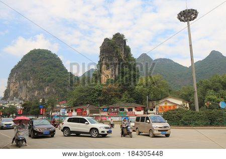 YANGSHOU CHINA - NOVEMBER 18, 2016: Unidentified people drive in Yangshou town centre.