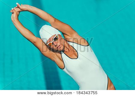 Female swimmer streching on poolside, horizontal image