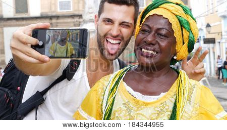 Tourist taking a selfie with a Baiana in the old colonial district of Salvador, Brazil