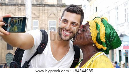 Tourist taking a selfie with a Baiana in the old colonial district of Salvador, Brazil