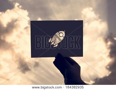 Hand Hold Space Rocket Paper Carving with Sky Background