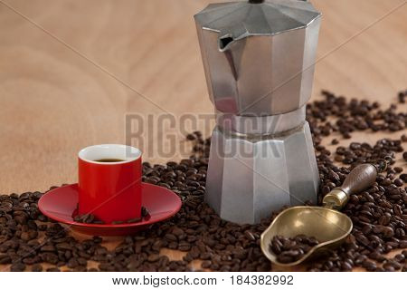 Coffee beans, coffee, coffeemaker and scoop on wooden background