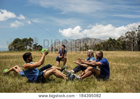 Fit people performing core exercise in bootcamp