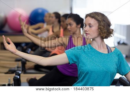 Group of women exercising on reformer in gym