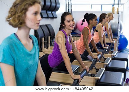 Group of women exercising on reformer in gym