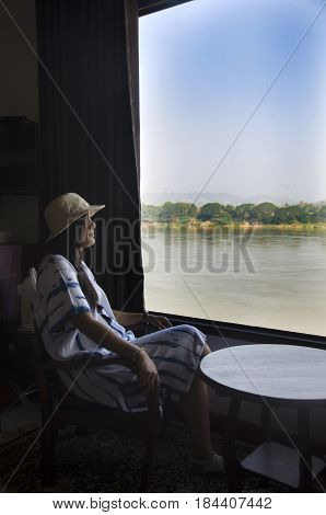 Alone Thai Woman Sitting On Chair Looking View Landscape And Flowing Of Mae Khong River