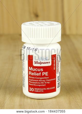 RIVER FALLS,WISCONSIN-MAY 02,2017: A bottle of Walgreens brand mucus relief tablets with a wood background.