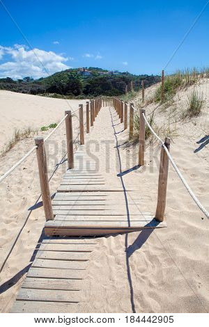 Wooden board path way to the sandy beach