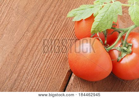 Fresh red tomatoes on wooden background. Place for text