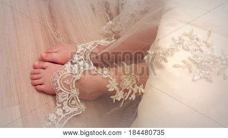 Tender feet girls look out from under a beautiful vintage lace dresses.