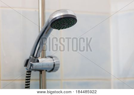 Bathroom sanitary objects details concept. Metal steel silver handshower under shower place