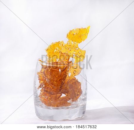 Abstract detail of cannabis oil concentrate aka shatter isolated against white background