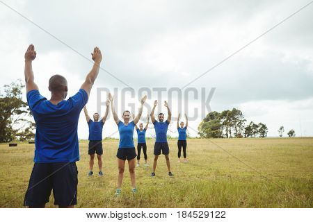 Fit people performing stretching exercise in bootcamp