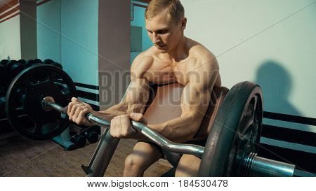 Man in the gym, exercise for the biceps