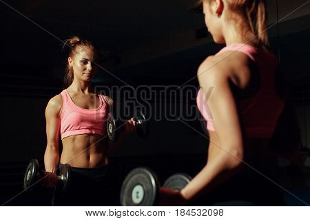 young woman in the gym, exercise for the biceps
