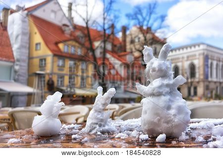 Hares of snow on the table in the city caf on the Livu square in Riga on a Sunny day in early spring