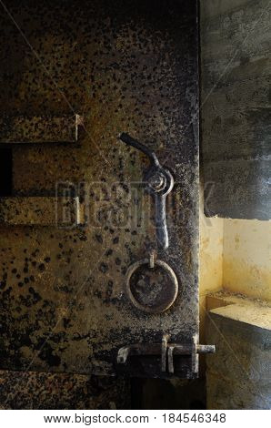 Rusty old heavy metal door in an underground bunker at Point du Hoc France.