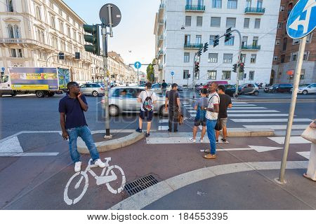 MILAN ITALY - September 06 2016: Pedestrians are waiting the green light of traffic light on the crossroad on Avenue Buenos Aires (Corso Buenos Aires) and street Bastioni di Porta Venezia where there is a bicycle lane for bicyclists