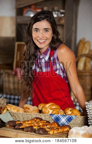 Portrait of female staff standing at bakery section in supermarket