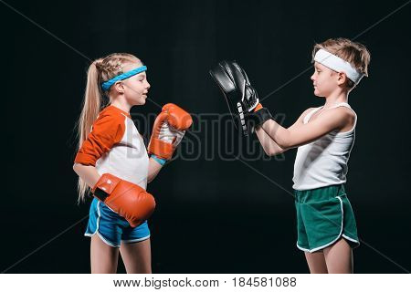 Side View Of Kids Pretending Boxing Isolated On Black, Active Kids Concept