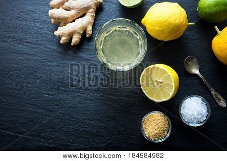 Natural isotonic drink lemonade with salt and ginger. Glass of spice lemonade with salt and ginger on black background with copy space. Top view.