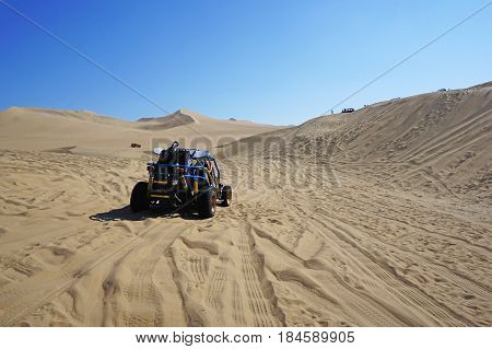 A dune buggy taking a ride through mountains of sand in Huacachina, Peru